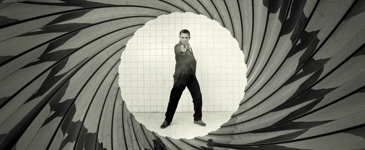 Black and white image of Daniel Craig's Bond, pointing straight at the camera with his gun