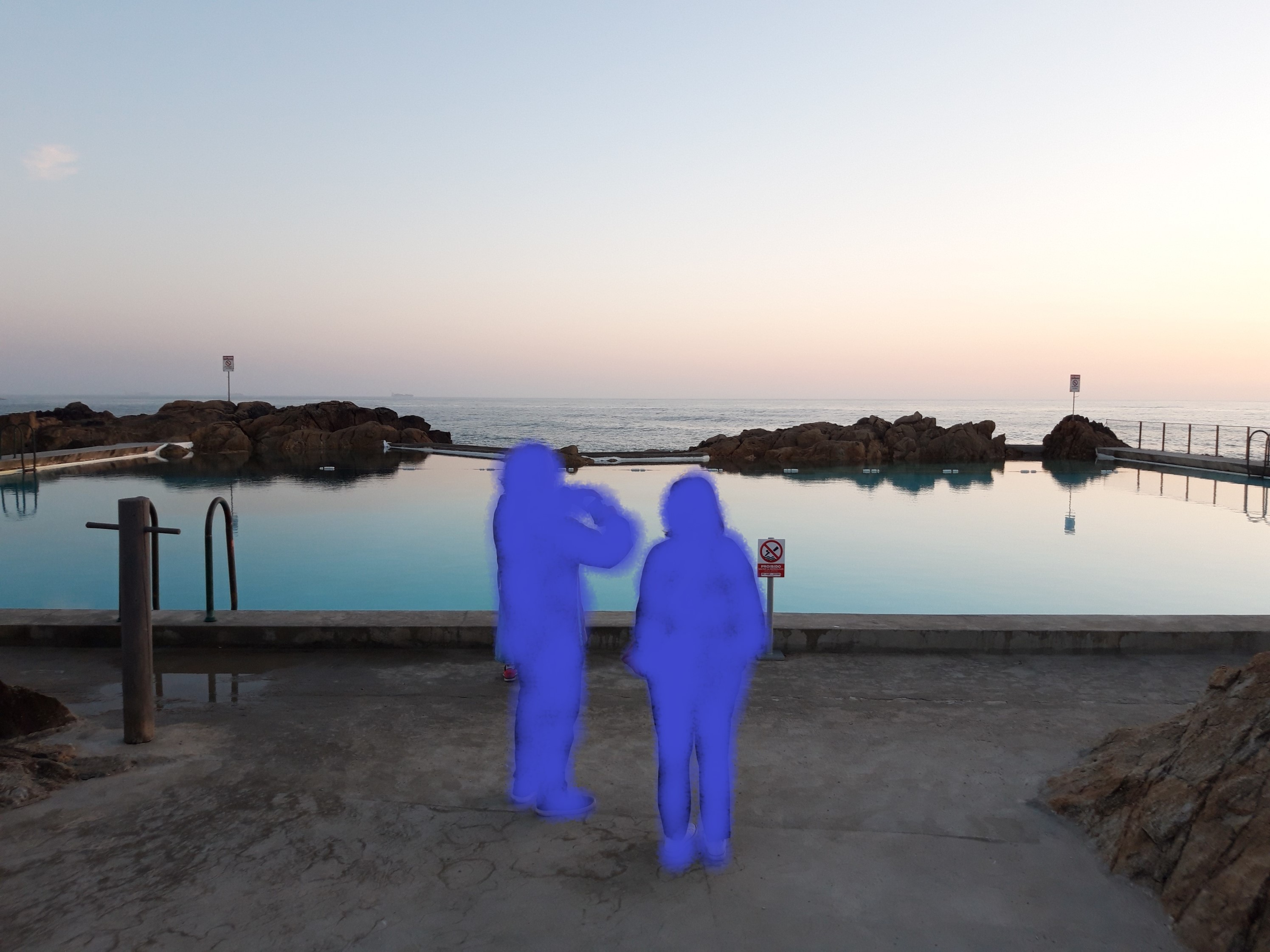 swimming pool at sunset,two blue figures stand in the middle of the picture